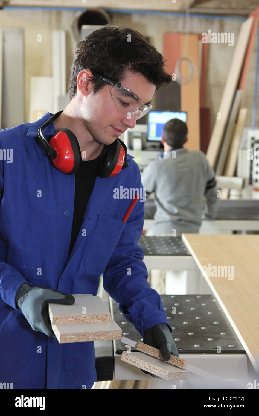 Worker collecting pieces of wood Stock Photo - Alamy