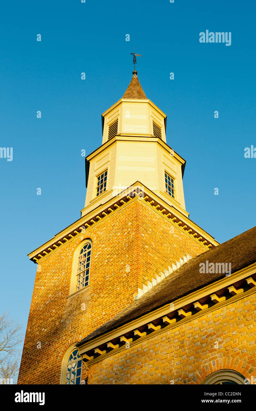 Warm sunlight at sunrise illuminates the brick tower of Bruton parish church in Williamsburg Stock Photo