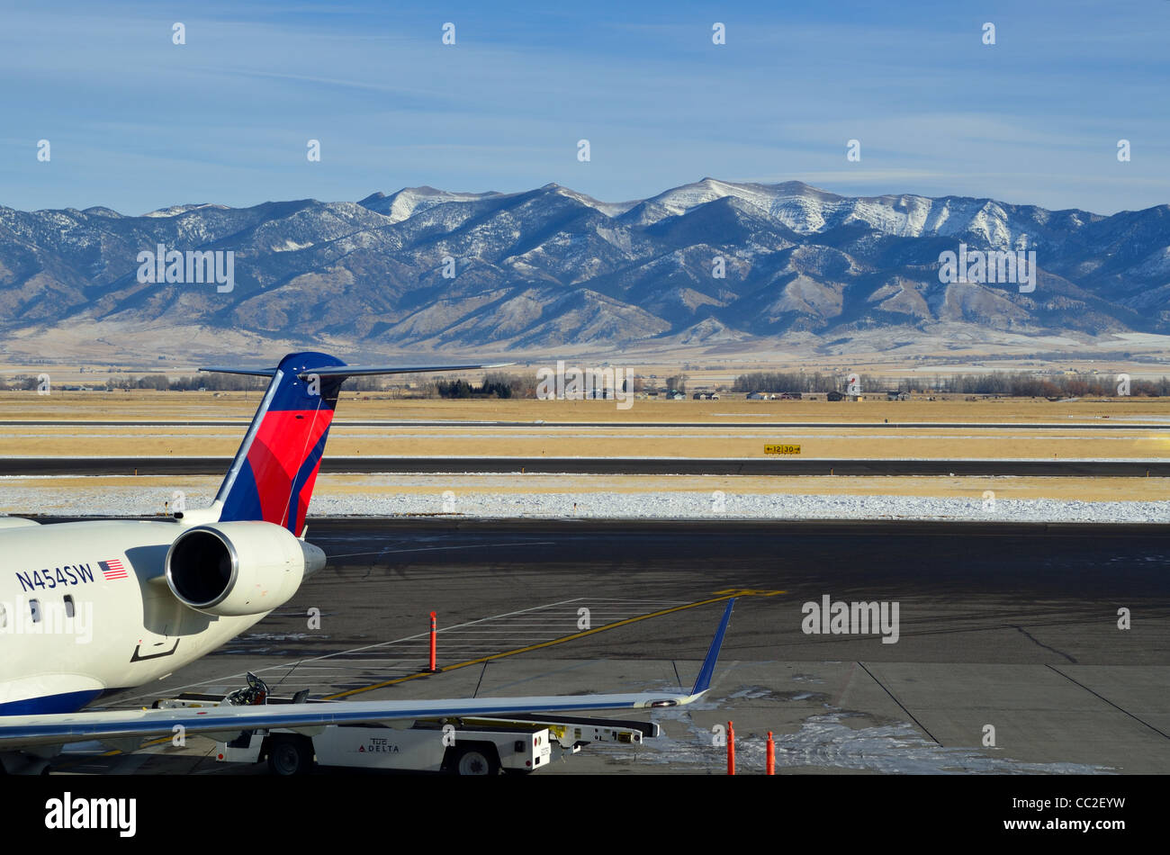 Airliner parked at the terminal, mountains as back drop. USA. Stock Photo