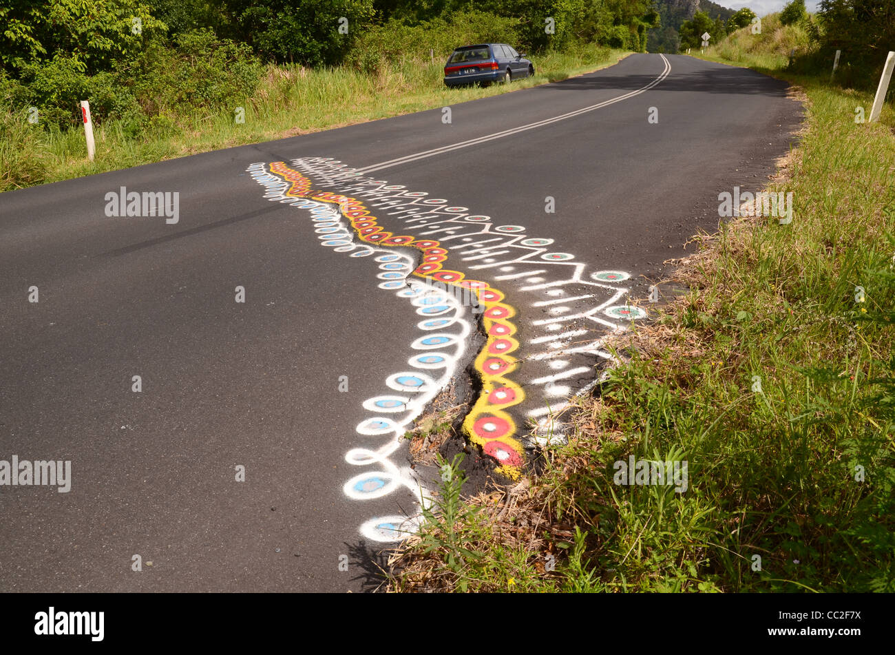 Damaged road highlighted by hippie artists Stock Photo