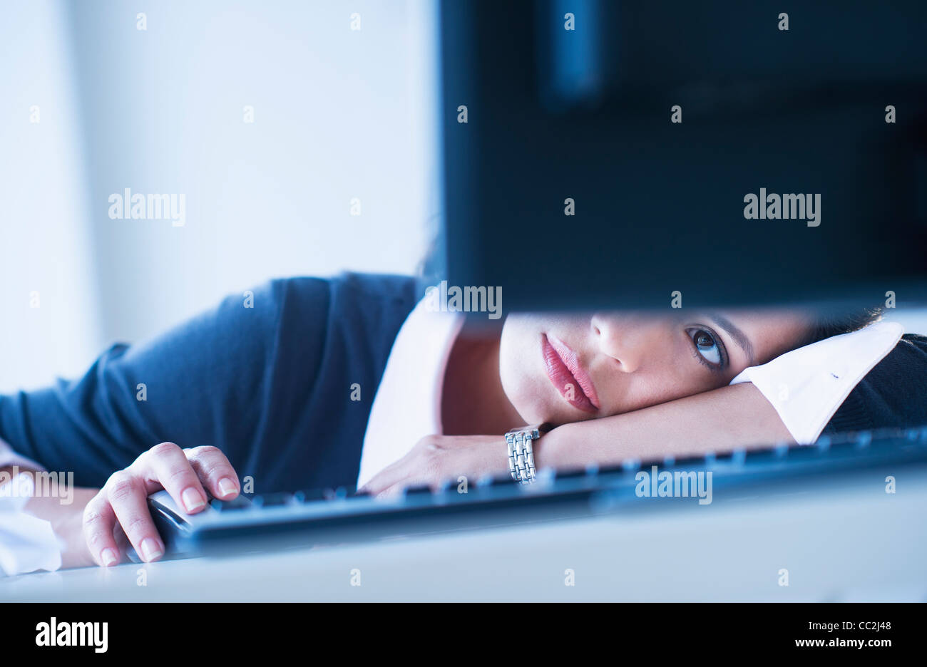 USA, New Jersey, Jersey City, Businesswoman looking tired in front of computer Stock Photo