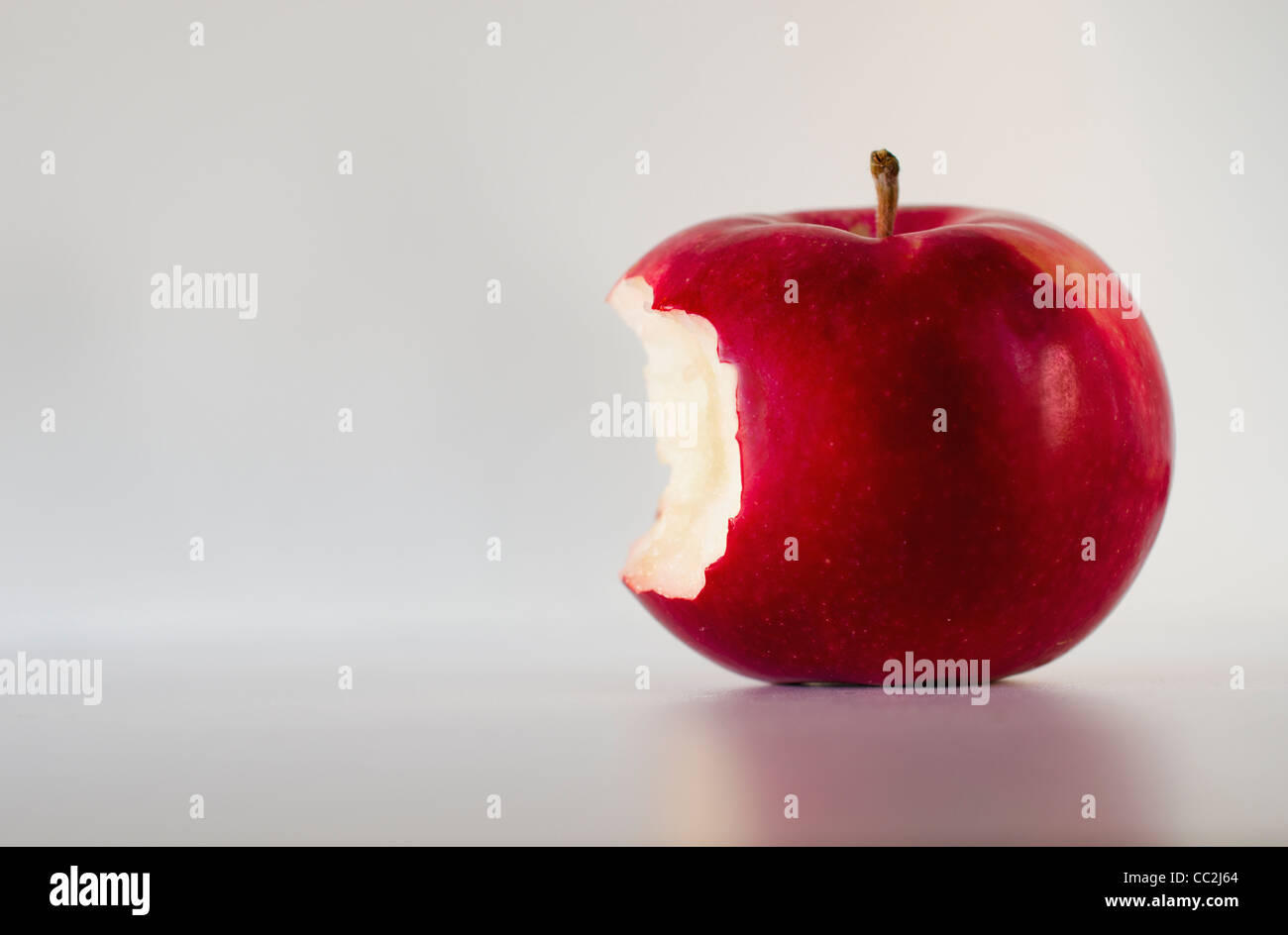 Red apple with missing bite, studio shot Stock Photo