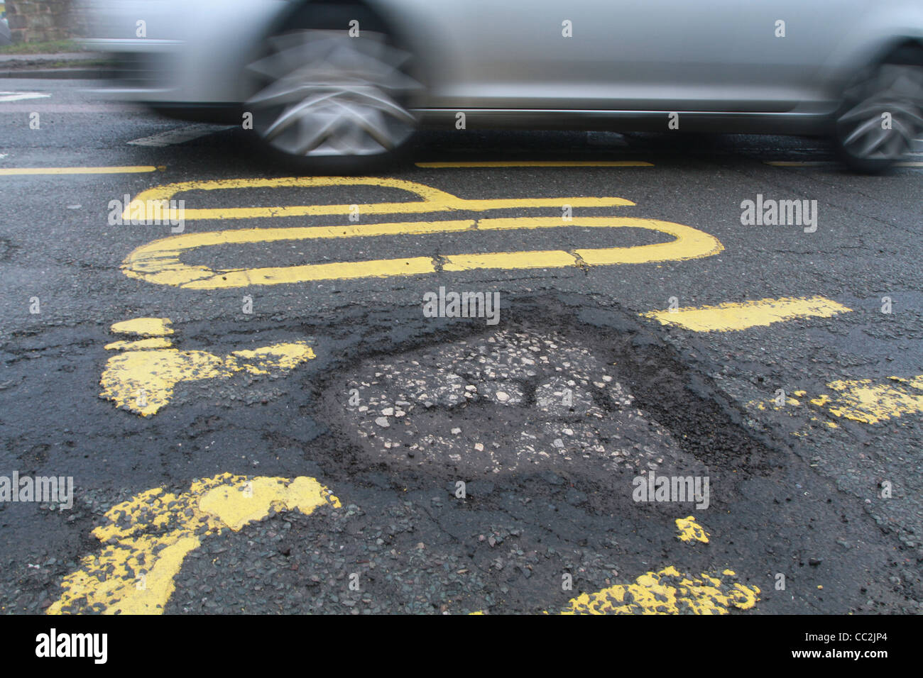 car driving past pothole Stock Photo