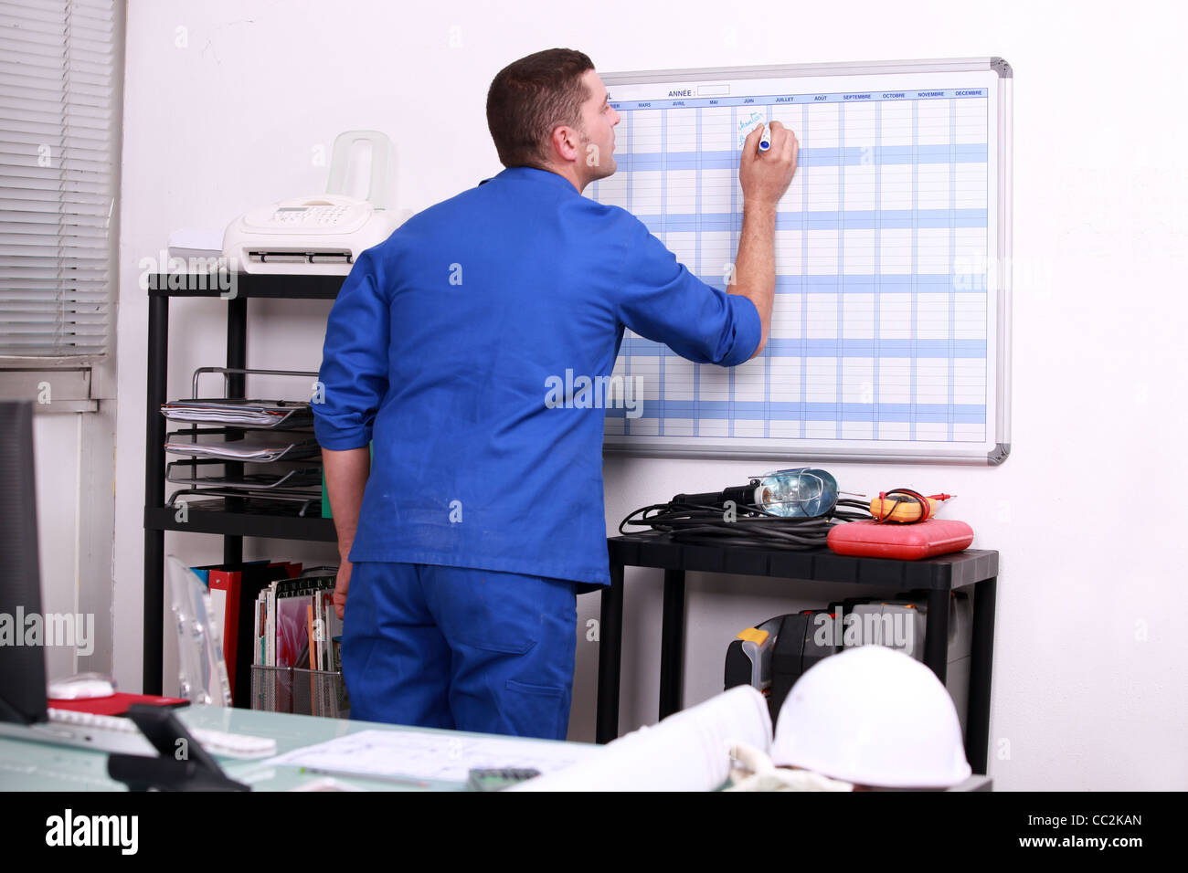 Factory worker marking date on calendar Stock Photo Alamy