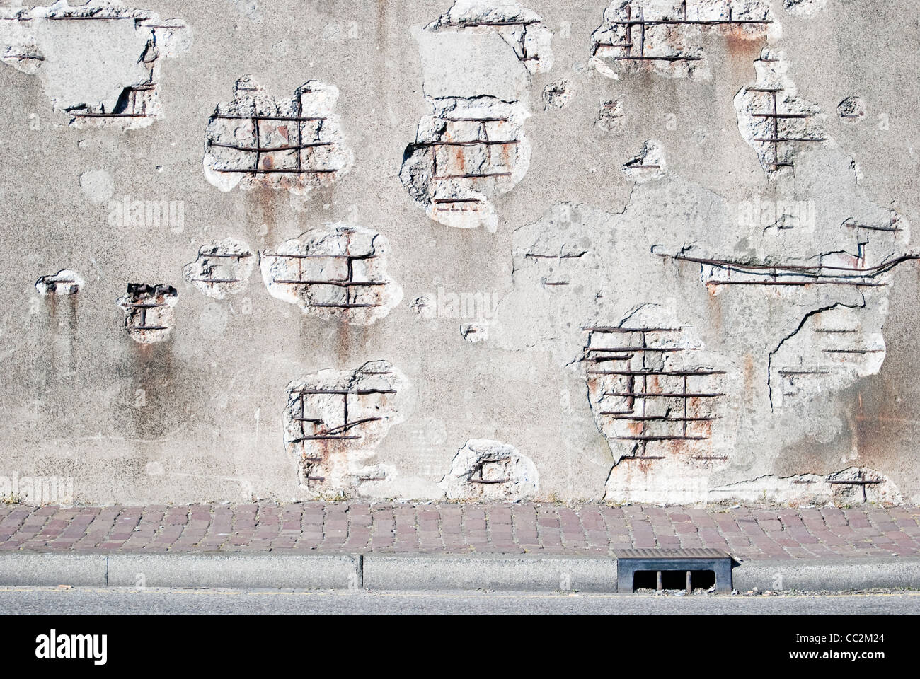 Decaying concrete wall with sidewalk Stock Photo