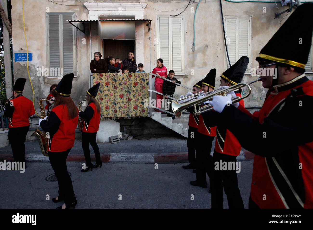 An Israeli Arab Christian marching band passing by a Muslim family