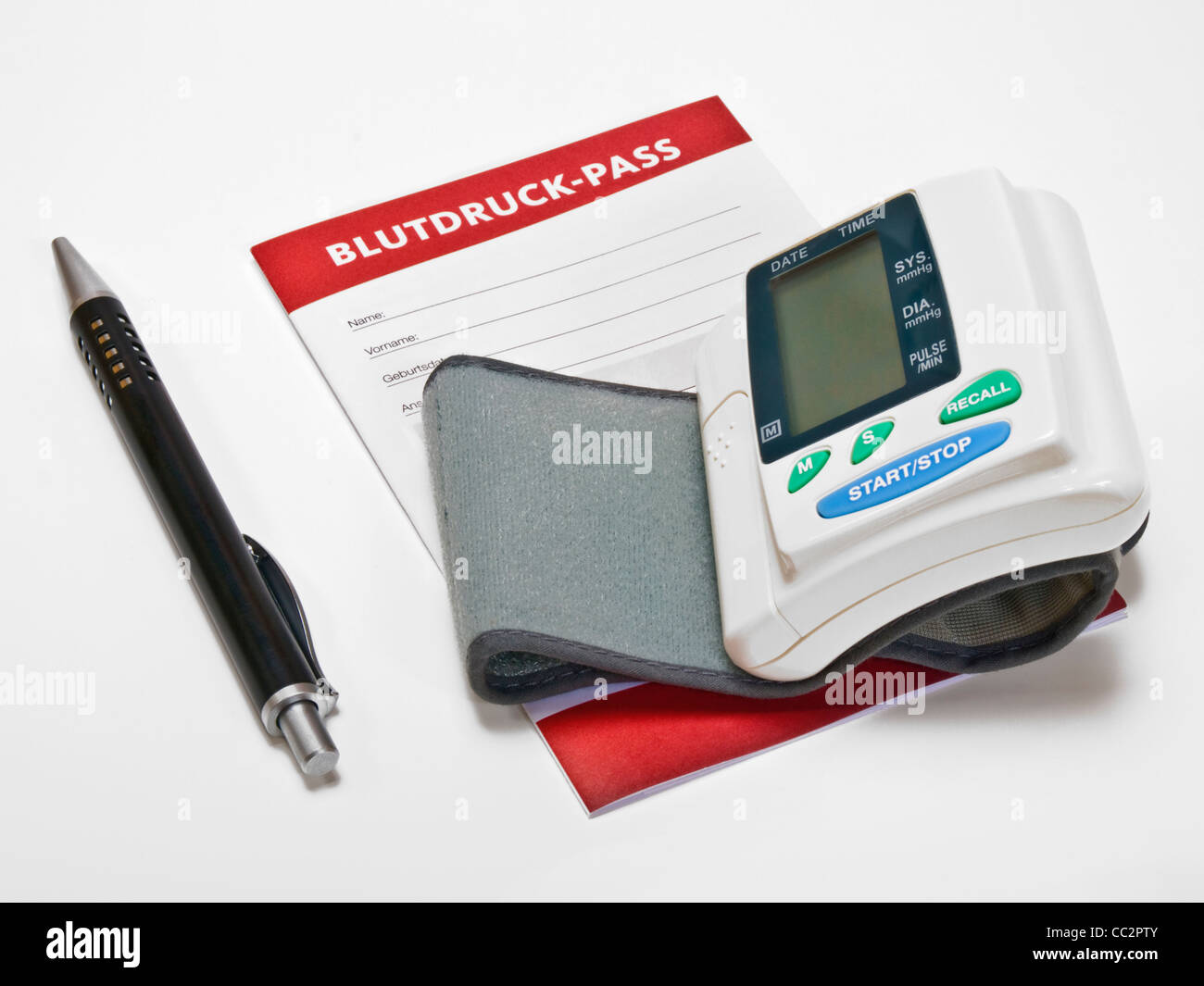 a Sphygmomanometer, beside is a blood pressure pass and a ball point pen Stock Photo