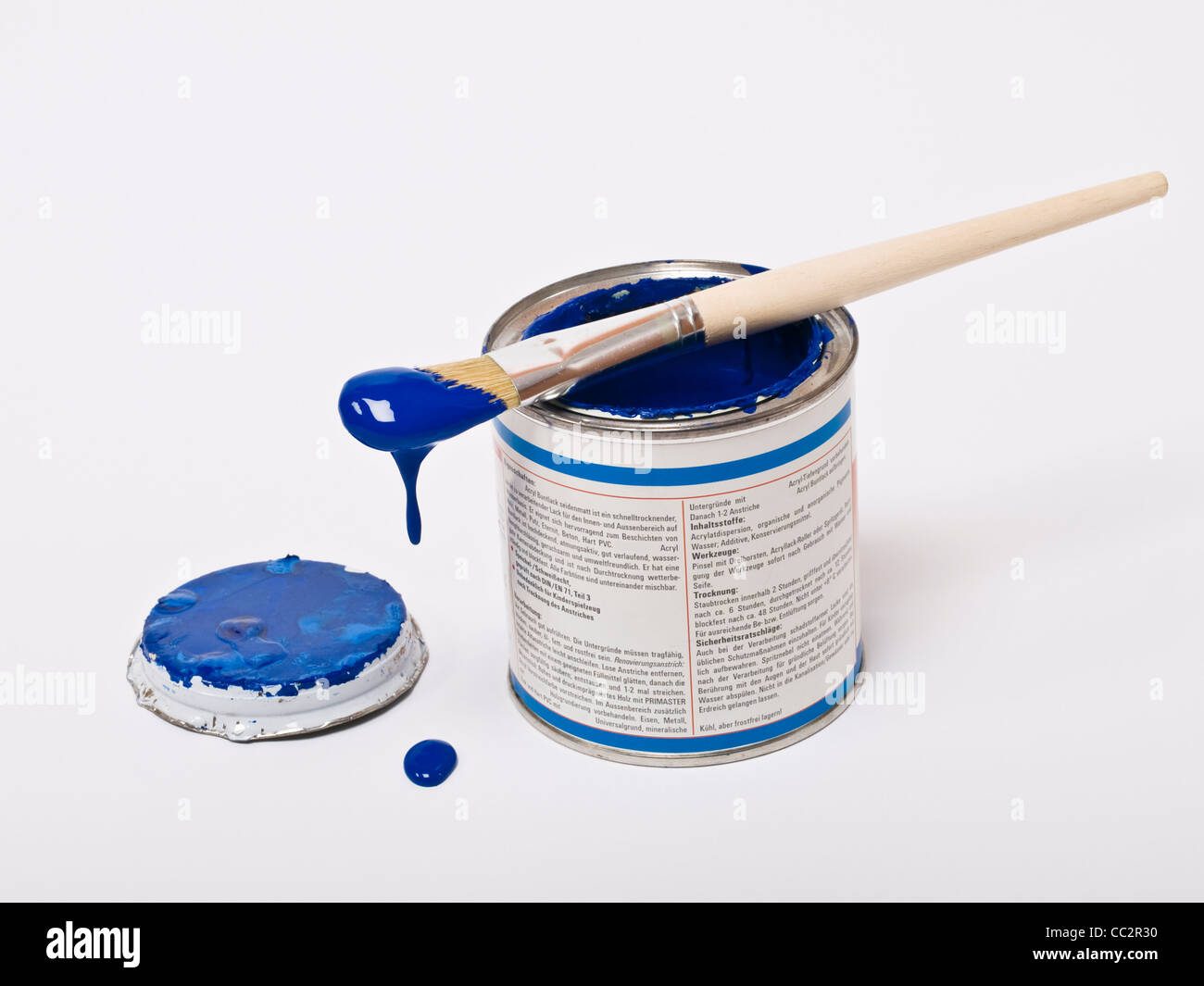 a brush is to drop at a tin with blue color Stock Photo