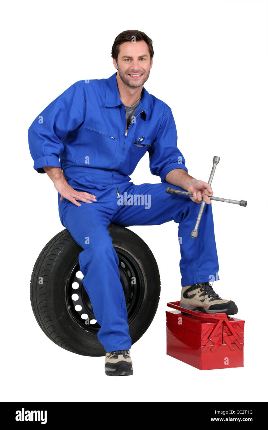 Mechanic with tyre and tools Stock Photo
