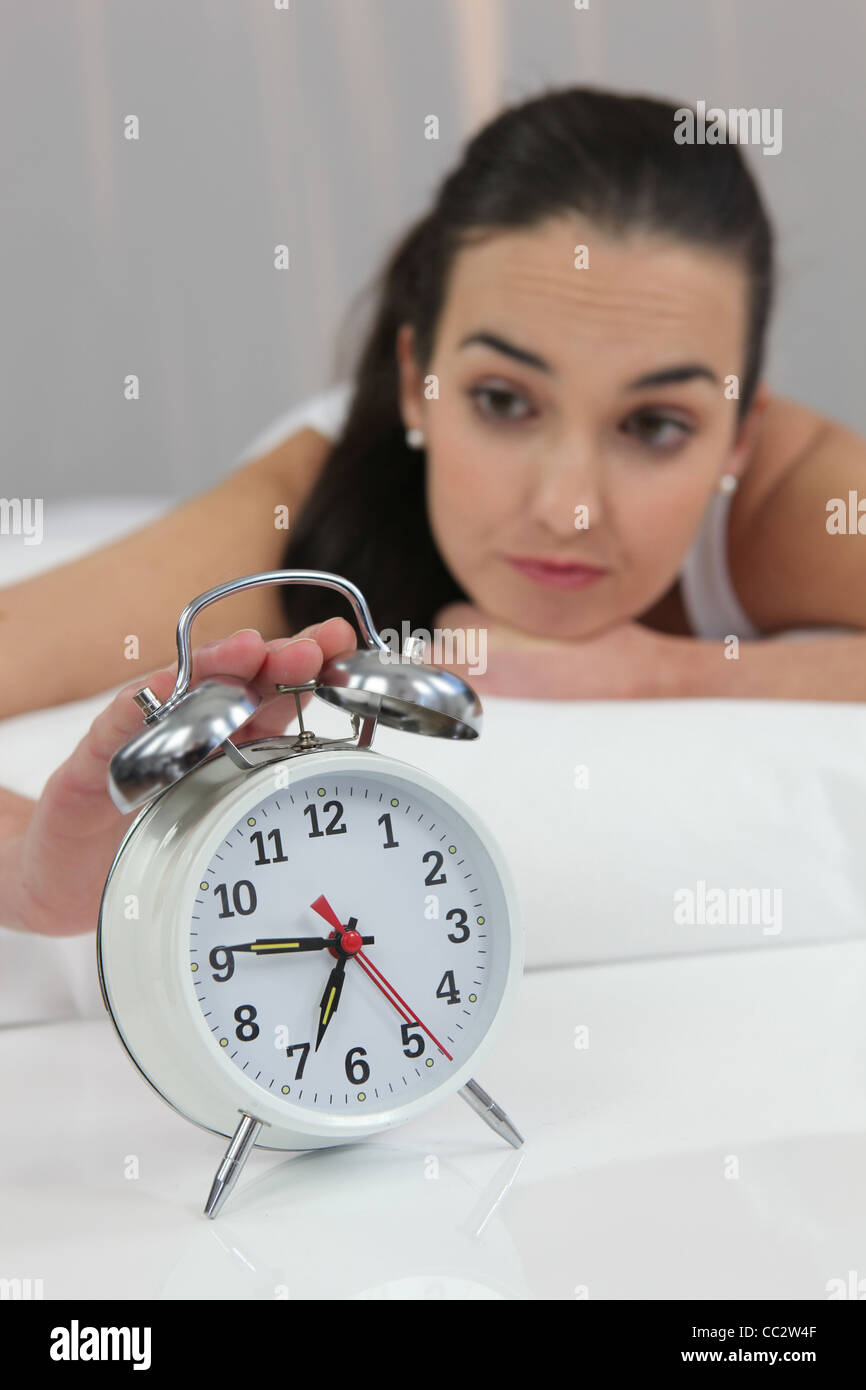 a woman stopping an alarm clock Stock Photo Alamy