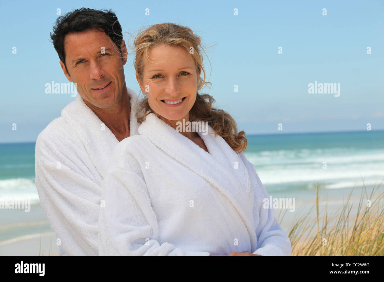 couple in robes on the beach Stock Photo - Alamy