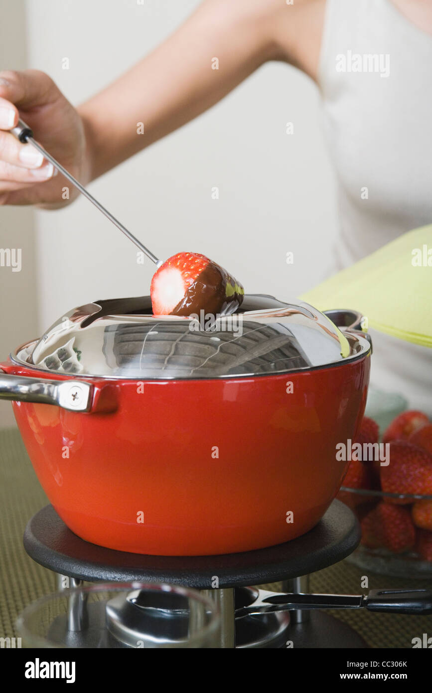 USA, California, Los Angeles, Woman dipping strawberries in chocolate mousse Stock Photo