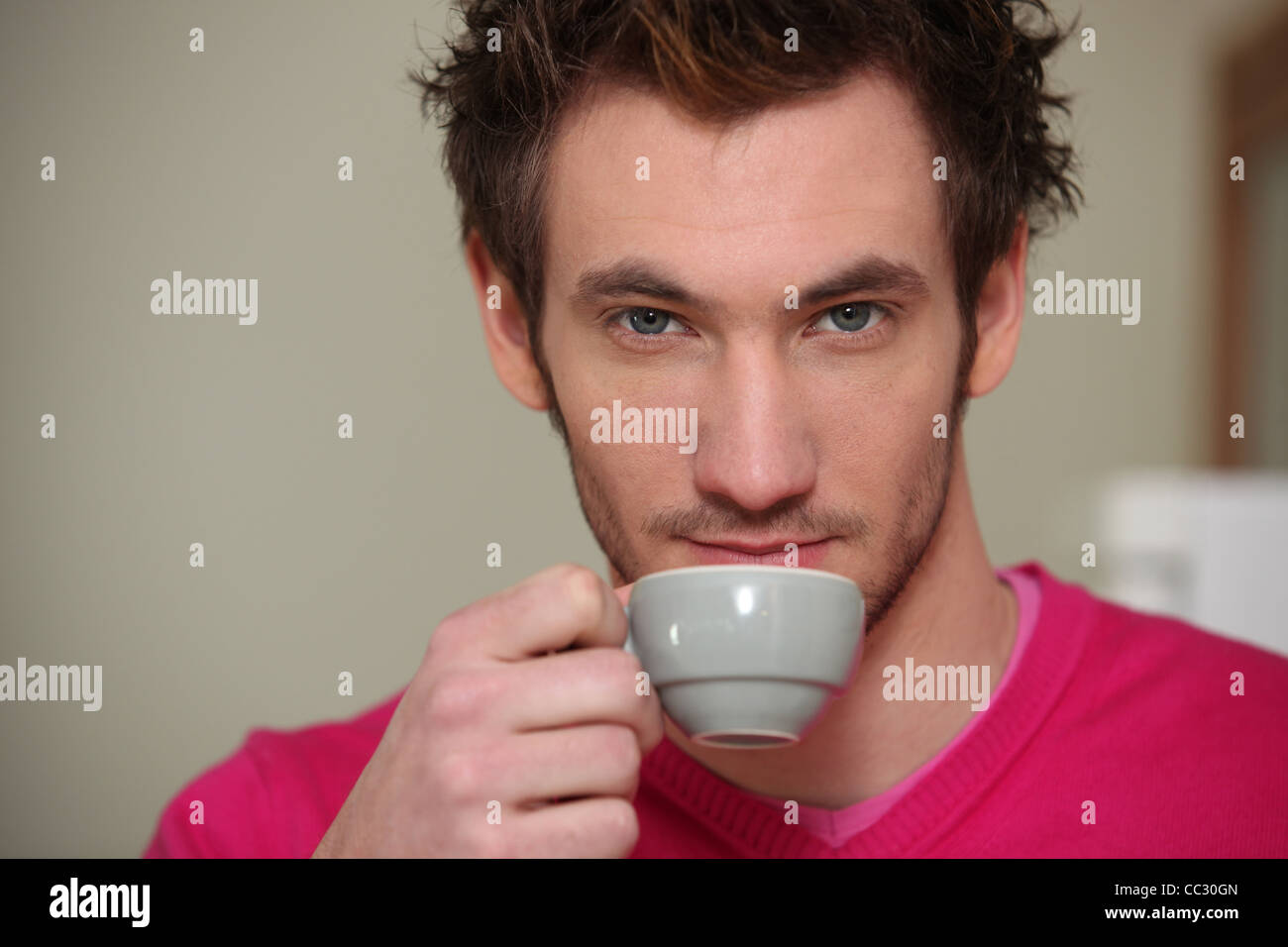 A serious man drinking a cup of coffee Stock Photo