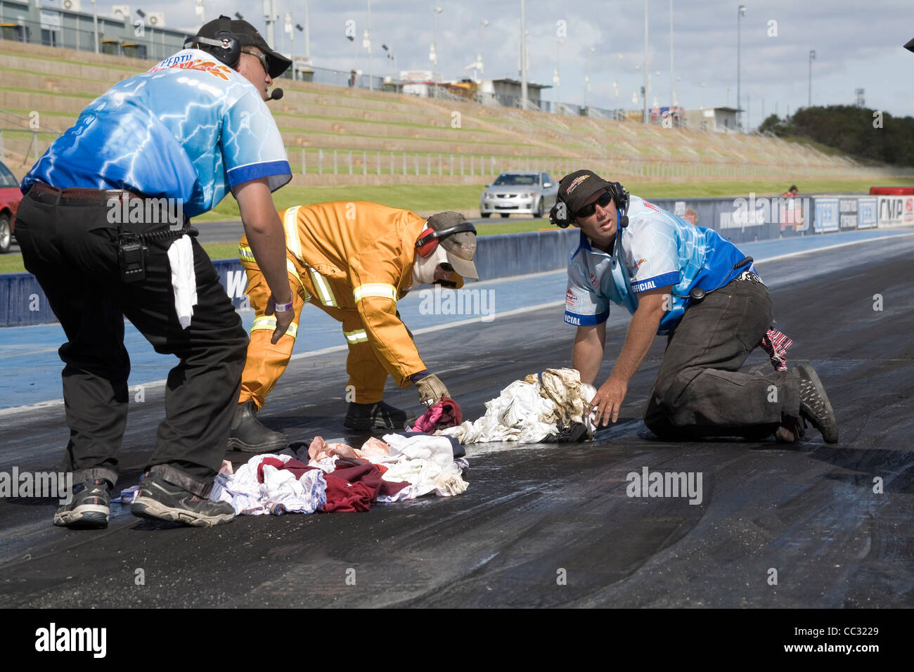 Drag racing track crew workers cleaning up an oil spill at a drag race meeting Stock Photo Alamy