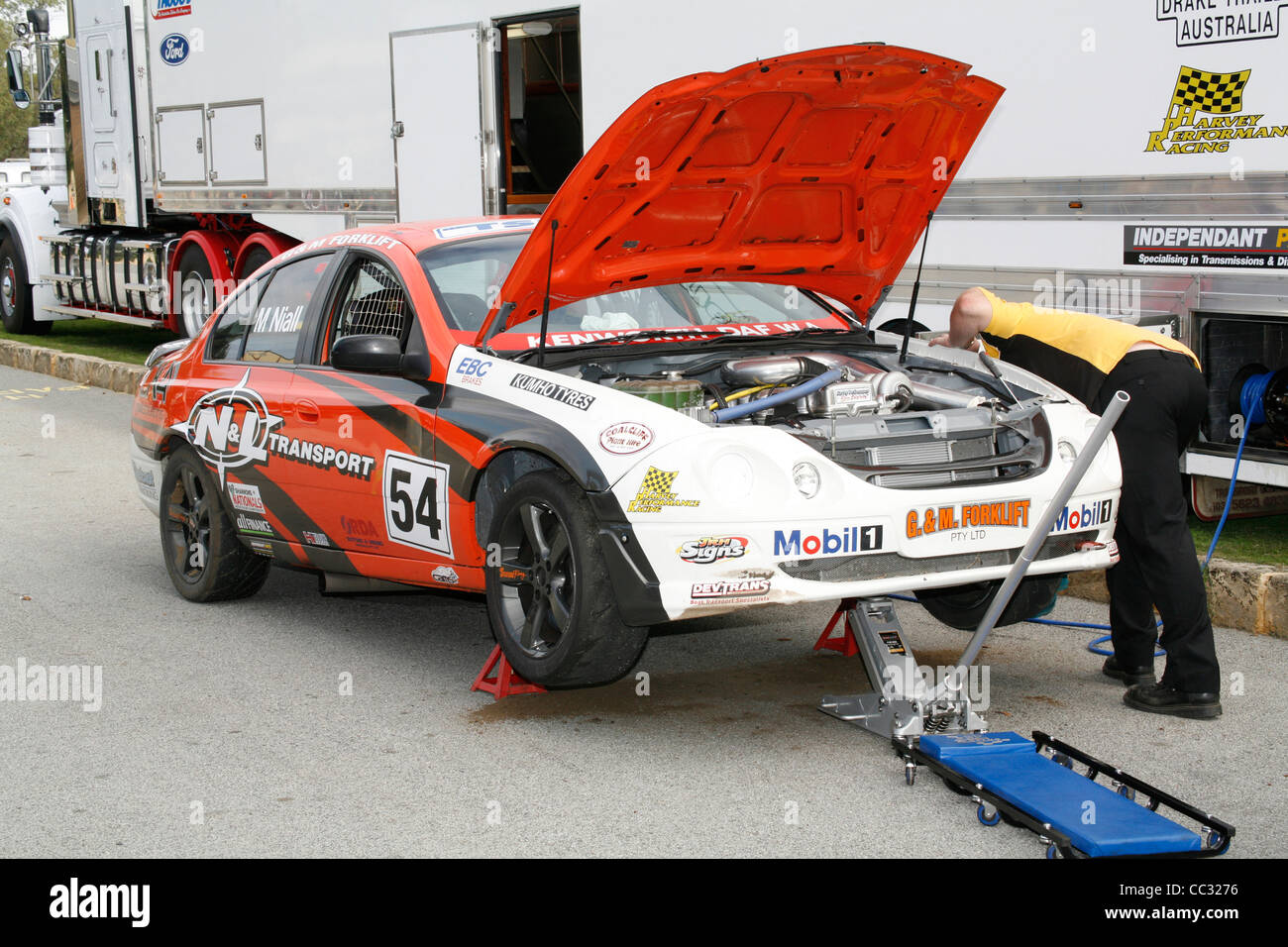 Australian Ford Falcon race car jacked up in the pits and being checked over by a mechanic. Stock Photo