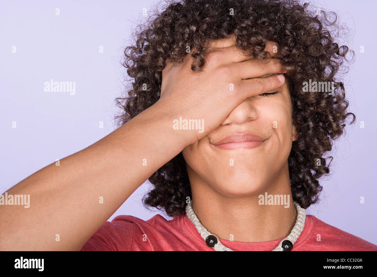Portrait of teenage boy (14-15) covering eyes with hand Stock Photo - Alamy