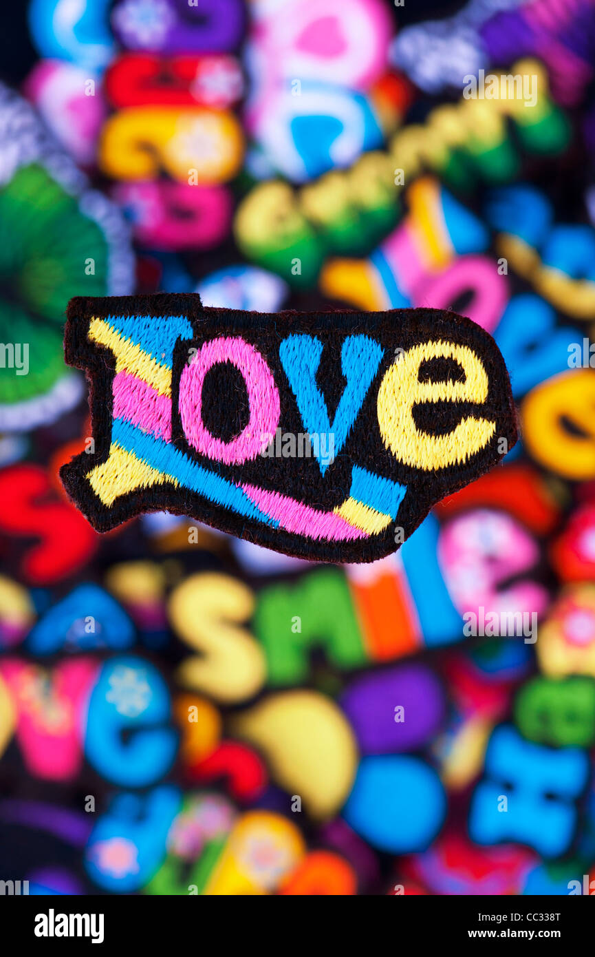 Embroidery iron on patches of Multicoloured Love, Peace, Happy, Smile, and  Groovy words on a black background Stock Photo - Alamy