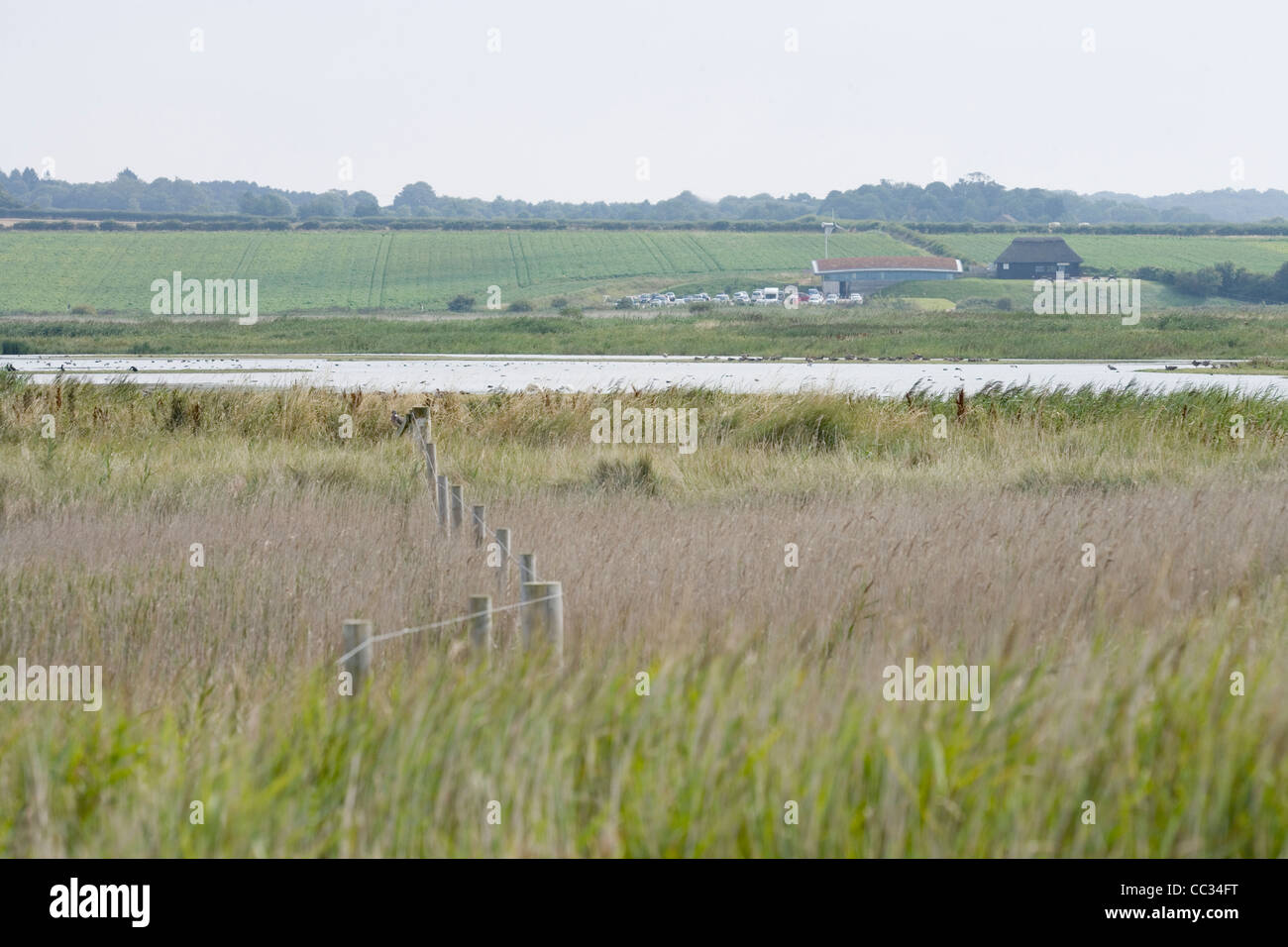 Norfolk Wildlife Trust, Cley Marshes Nature Reserve. View of Visitor Centre from hide looking across the North Scrape. Stock Photo