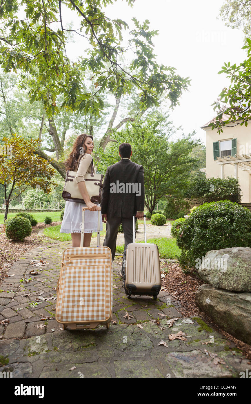 USA, New Jersey, Couple walking up path with luggage Stock Photo