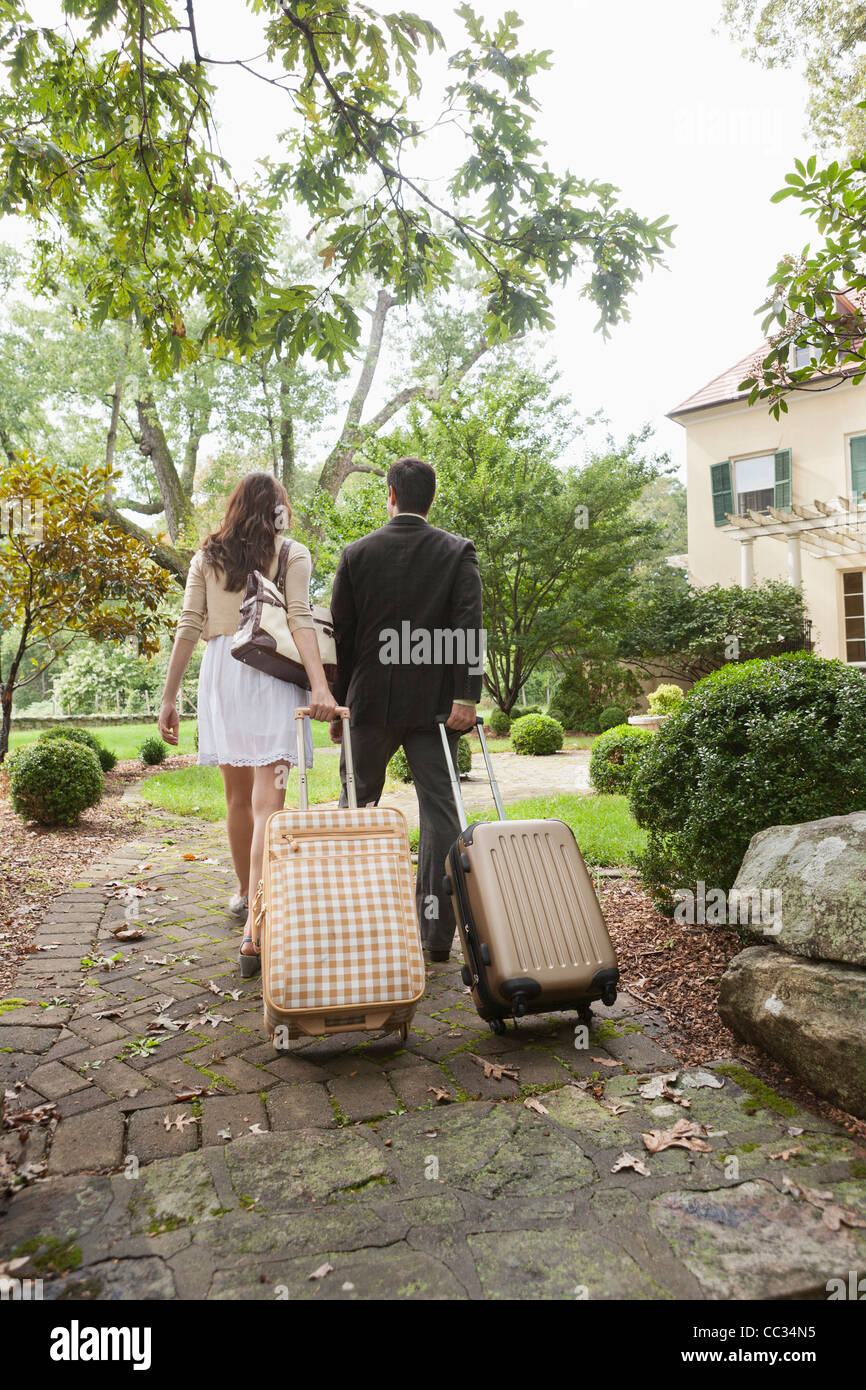 USA, New Jersey, Couple walking up path with luggage Stock Photo