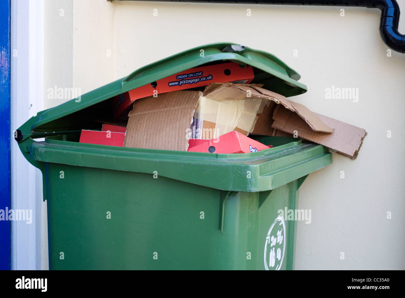 overflowing household recycling wheelie bin Stock Photo