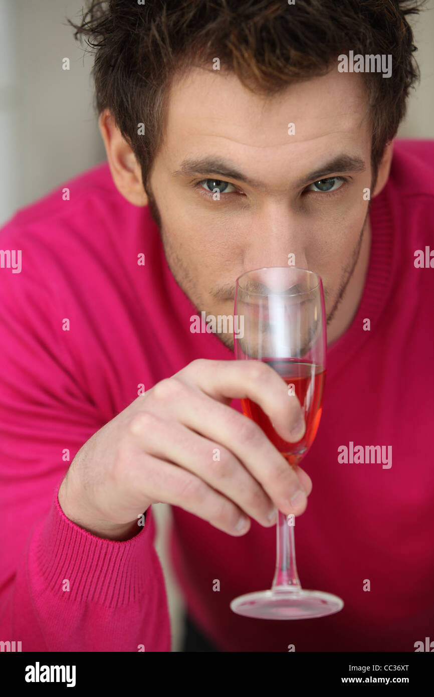 Young man smelling a glass of rose wine Stock Photo - Alamy