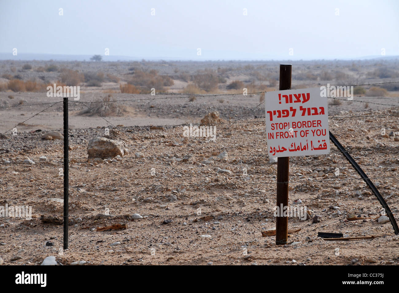 View of the fence and 'Danger Minds' marking the border between Israel and Jordan, Photo by Shay Levy Stock Photo