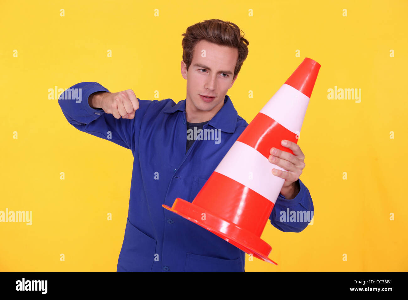 man hitting a traffic cone Stock Photo Alamy