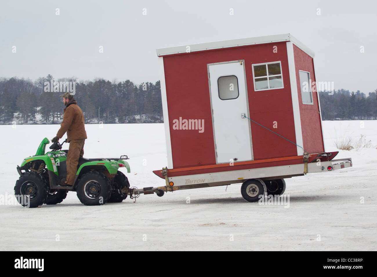 A Four Wheeler pulling an Ice Fishing Shanty out onto frozen Boom Lake in  Rhinelander Wisconsin Stock Photo - Alamy