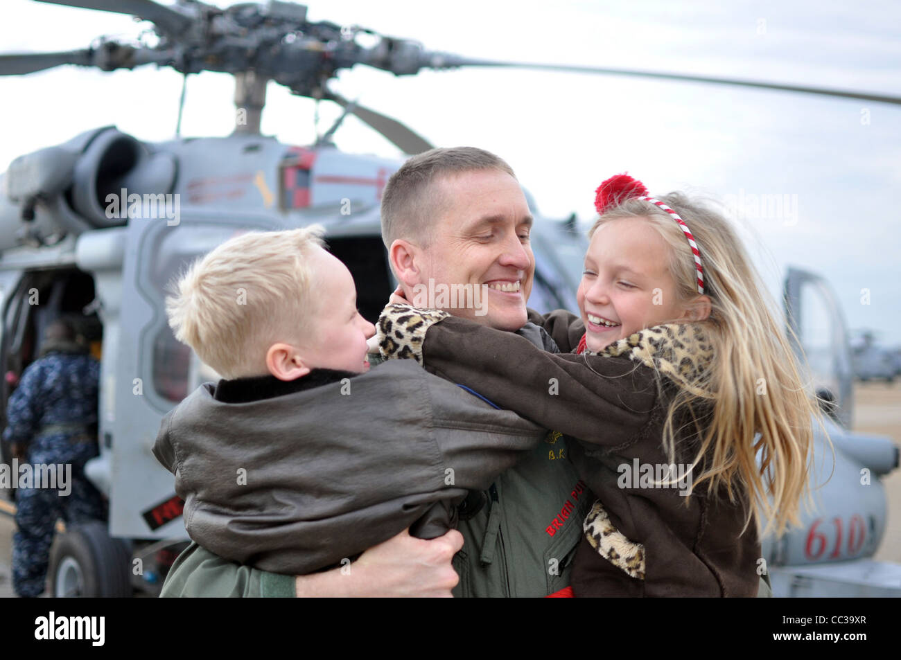 Brian Pummill, commanding officer of Helicopter Sea Combat Squadron, hugs his children during the squadron's homecoming ceremony Stock Photo