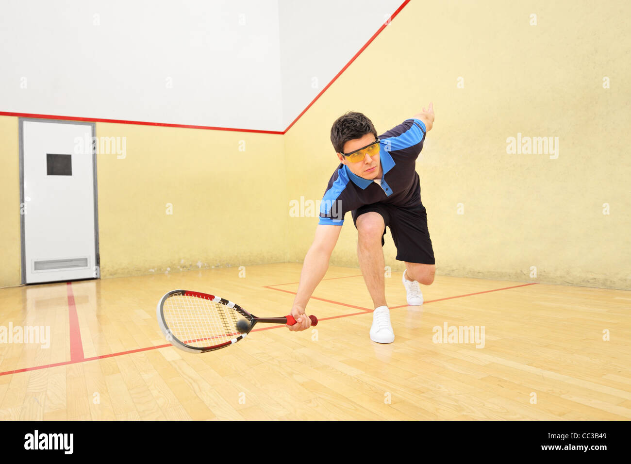 A young squash player hitting a ball Stock Photo Alamy