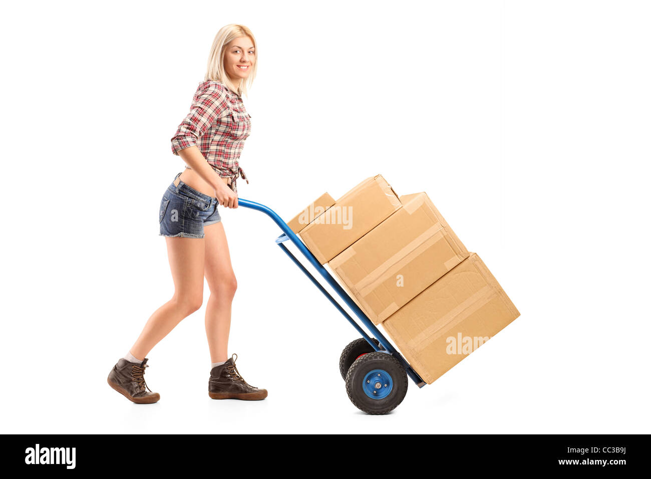 Full length portrait of a female manual worker pushing a handtruck with boxes on it Stock Photo