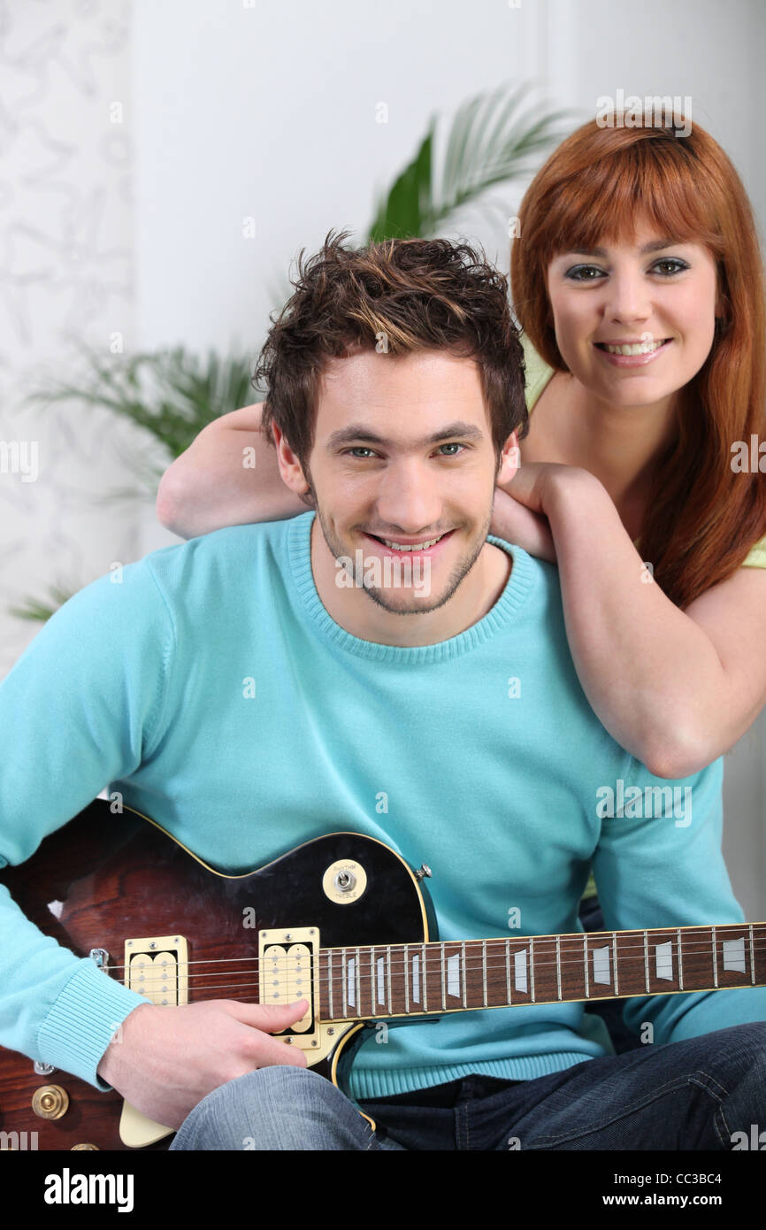 a man playing guitar and his girlfriend Stock Photo