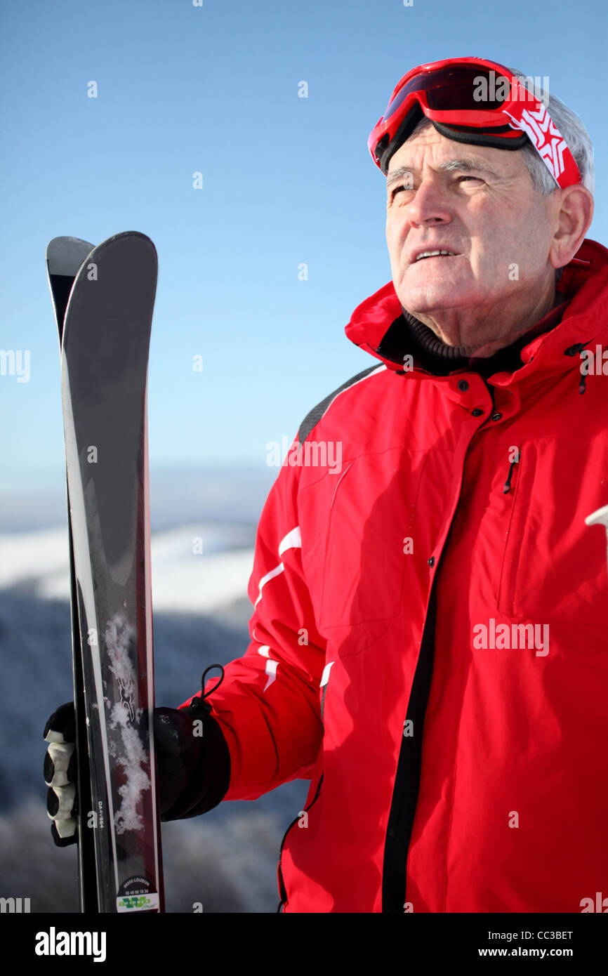 Older man on a mountain with skis Stock Photo - Alamy