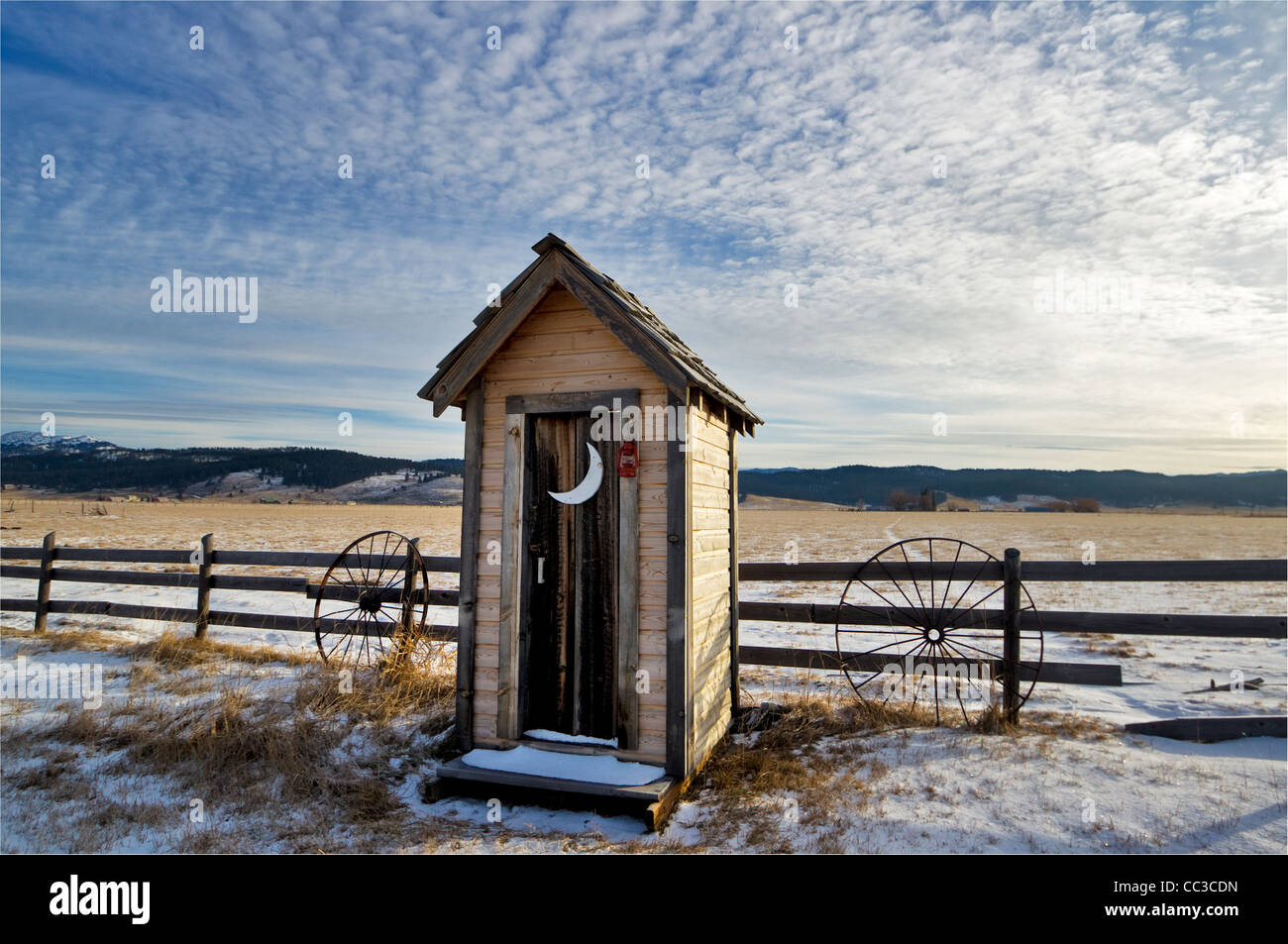 Out in a field covered with snow is this western outhouse Stock Photo