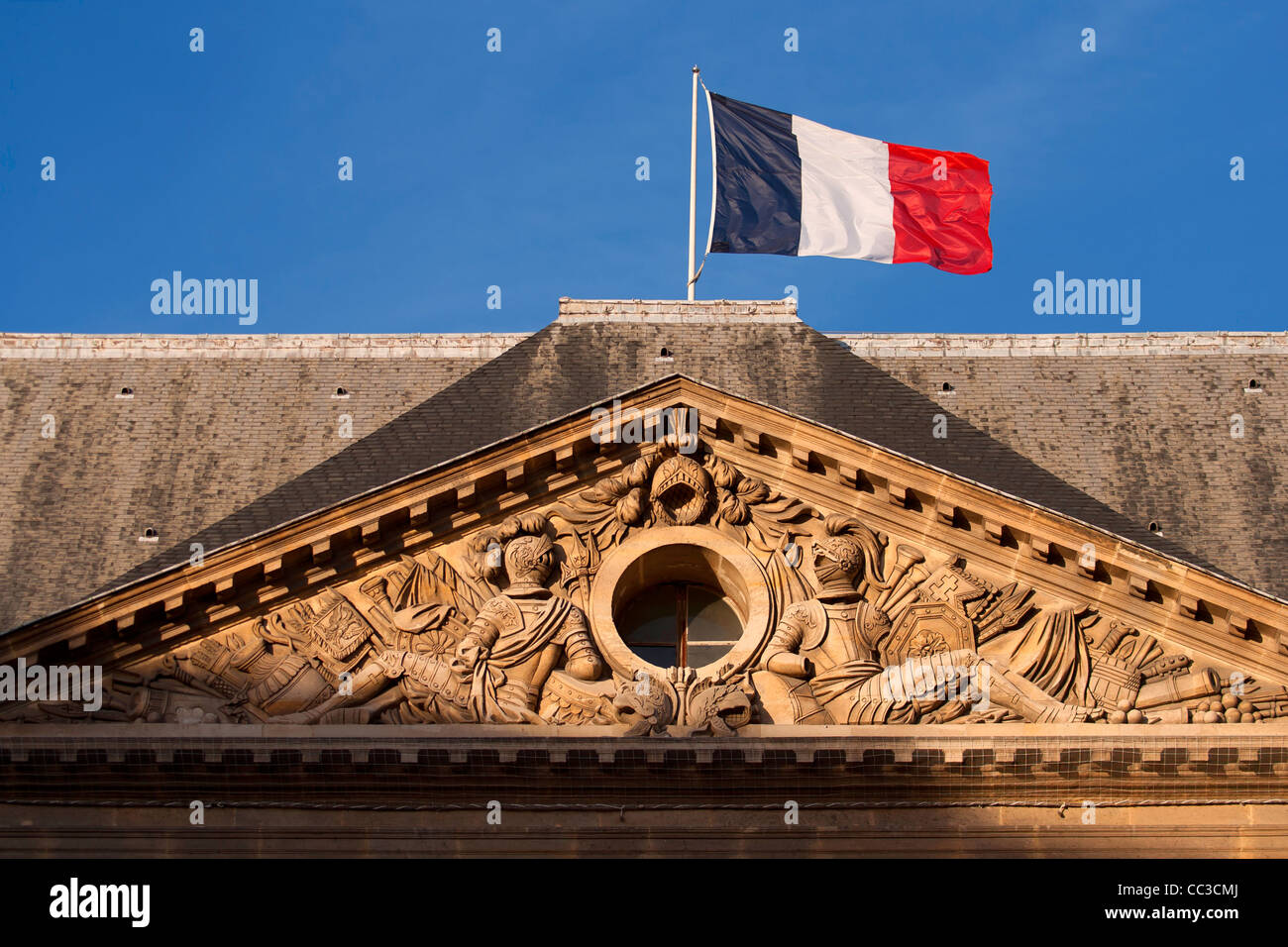 French flag flying above relief sculpture in the Cour d'honneur at Les Invalides, Paris, France Stock Photo