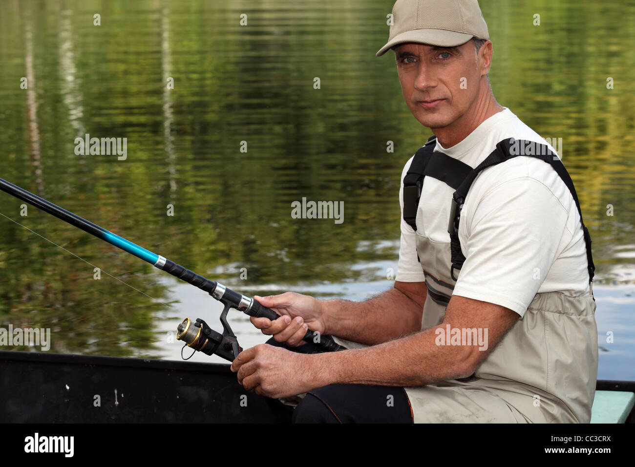 45 years old man on a boat and fishing Stock Photo