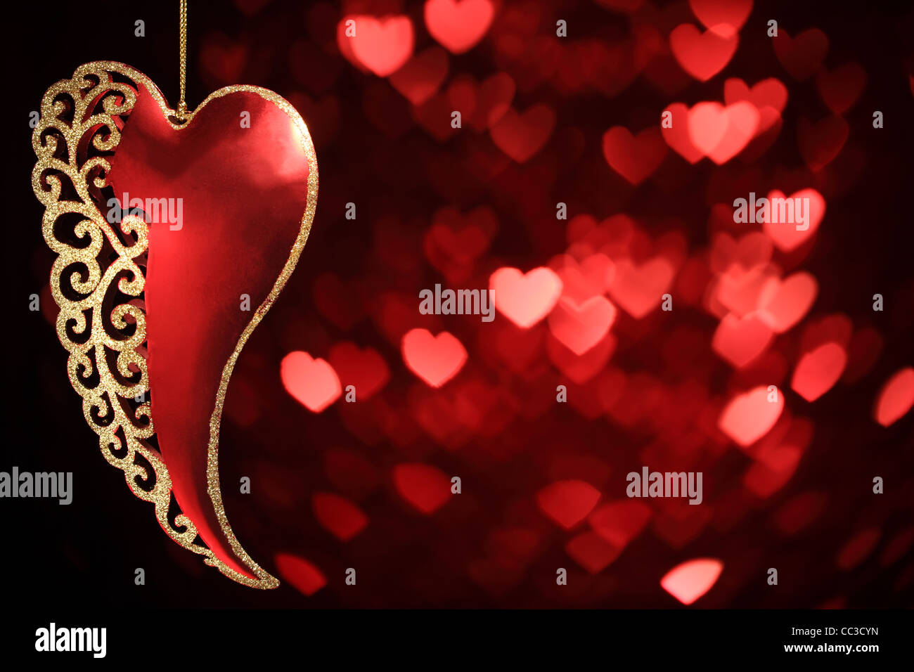 Heart shaped ornament hanging on defocused bokeh background Stock Photo