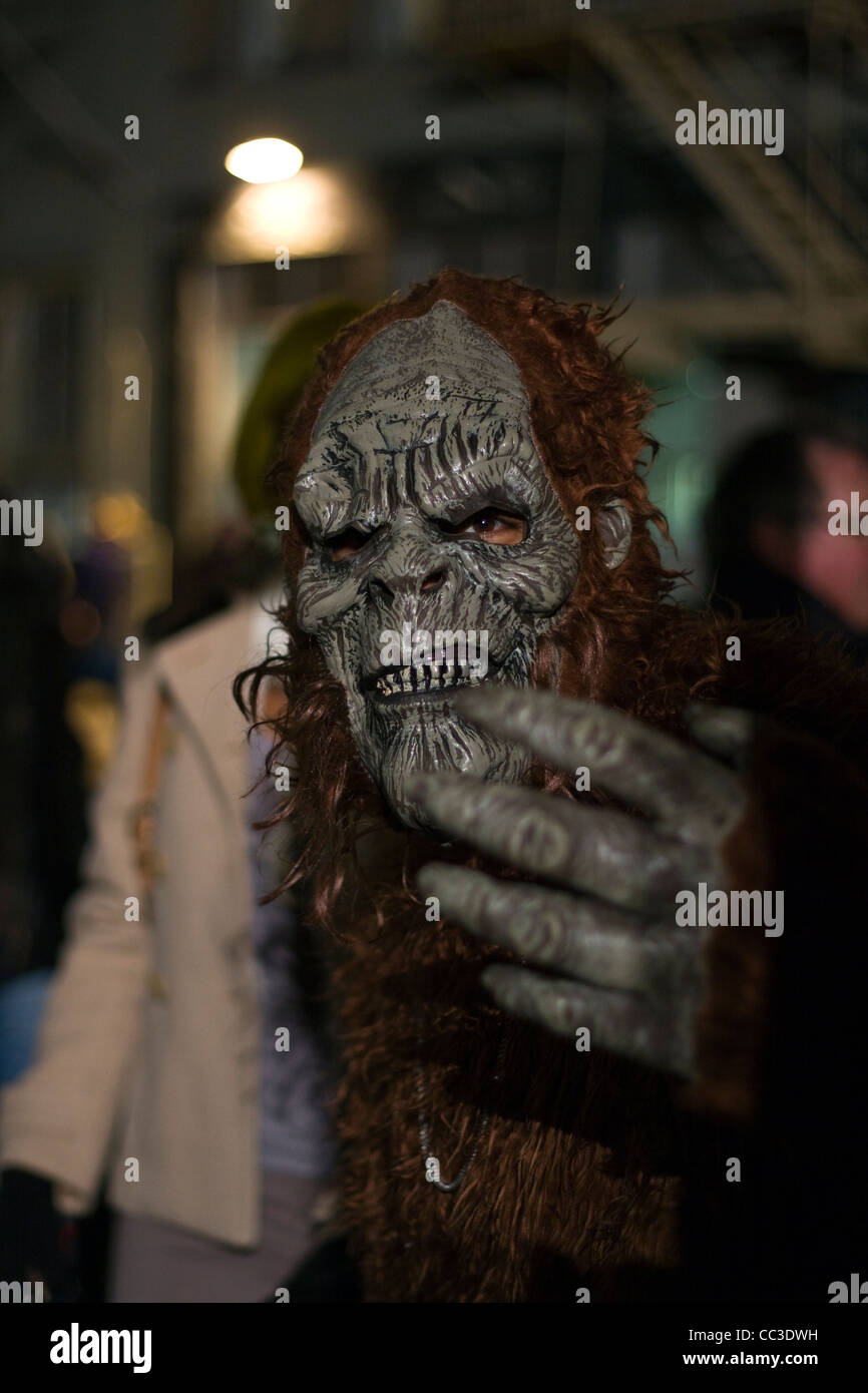 Man wearing a scary ape mask and costume participating in the Halloween Parade in NYC reaches towards the camera Stock Photo