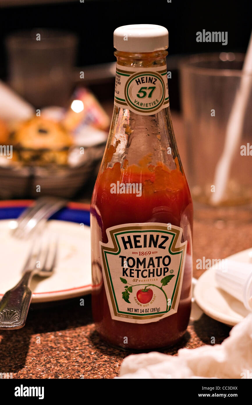 14oz Bottle of Heinz Tomato Ketchup sitting on table after a meal Stock Photo