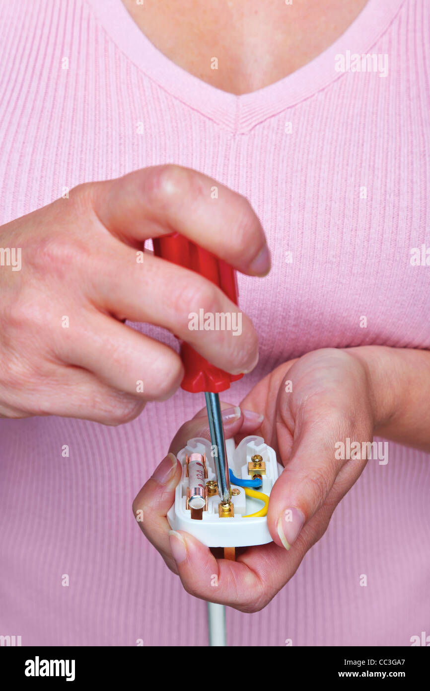 Photo of a woman fitting an electrical plug Stock Photo