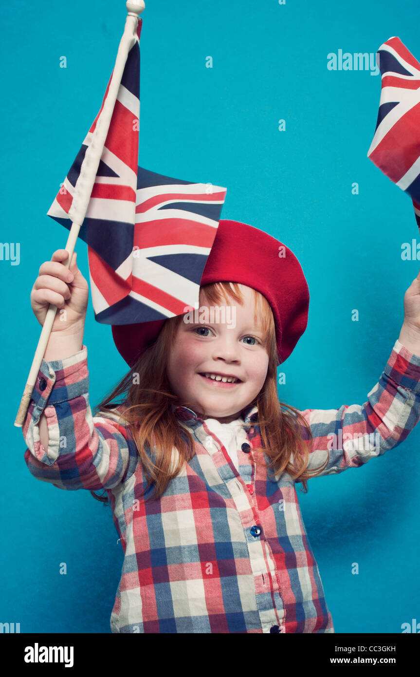 A young girl waving two British flags Stock Photo