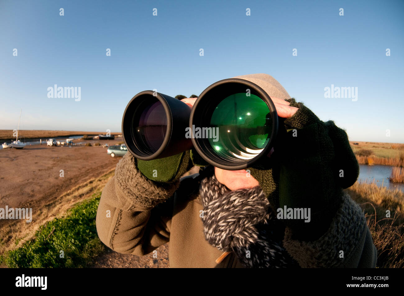 person looking through binoculars, blakeney, norfolk, england Stock