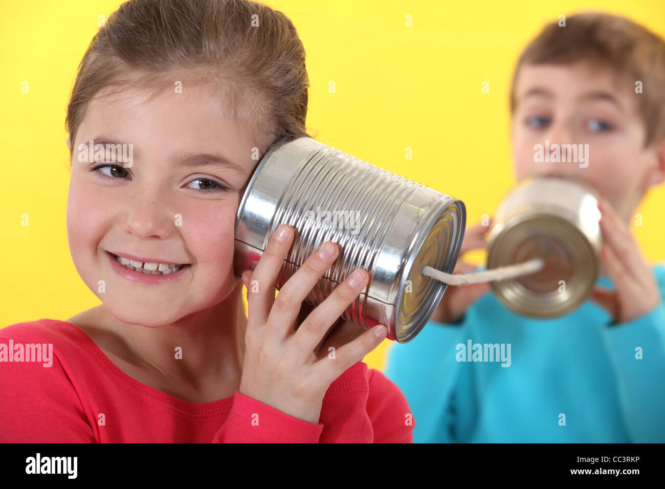 Kids using tin cans to communicate Stock Photo Alamy