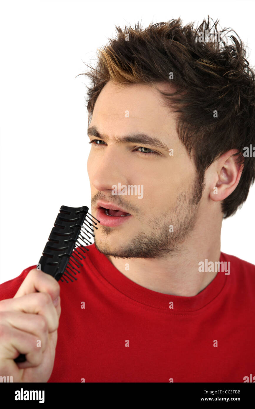 young man holding hairbrush as makeshift microphone Stock Photo Alamy
