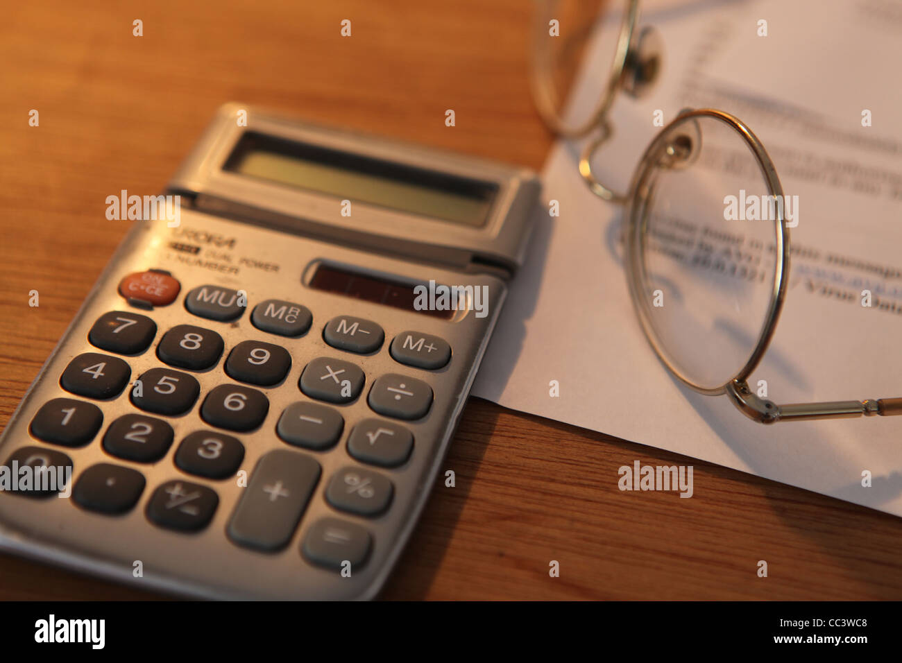 DESK WITH CALCULATOR AND GLASSES Stock Photo