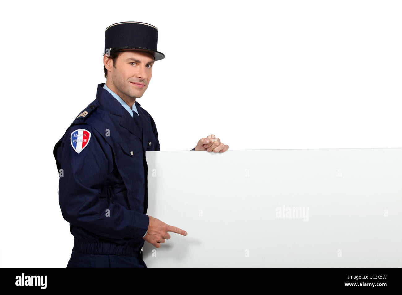 Man in a French gendarme uniform pointing at a blank board ready for text or image Stock Photo