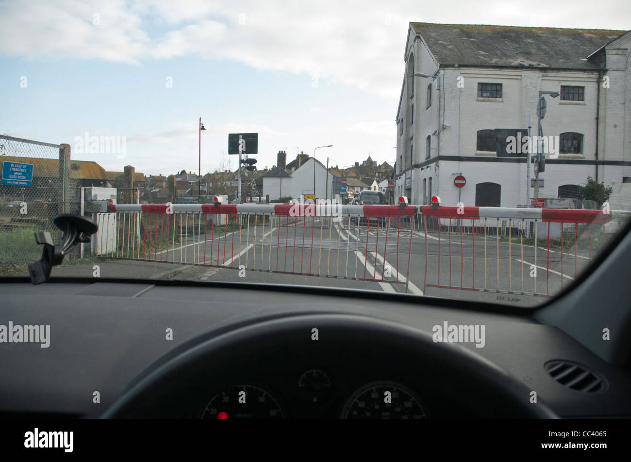 Train Railway Level Crossing With The Barriers Down As Seen Through A Car Windscreen Stock Photo