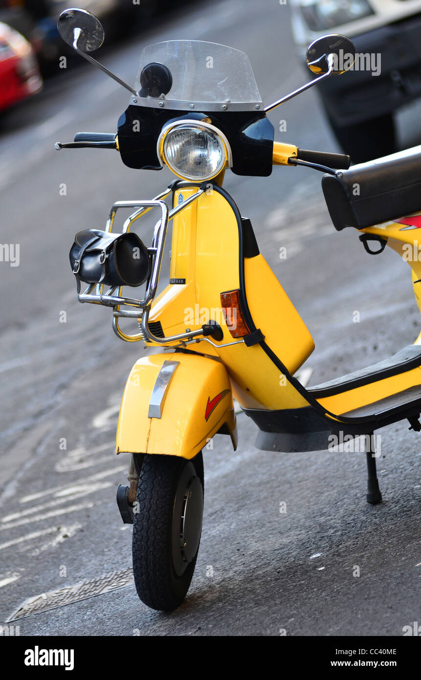 Yellow Scooter, moped, motorbike parked on the street Stock Photo