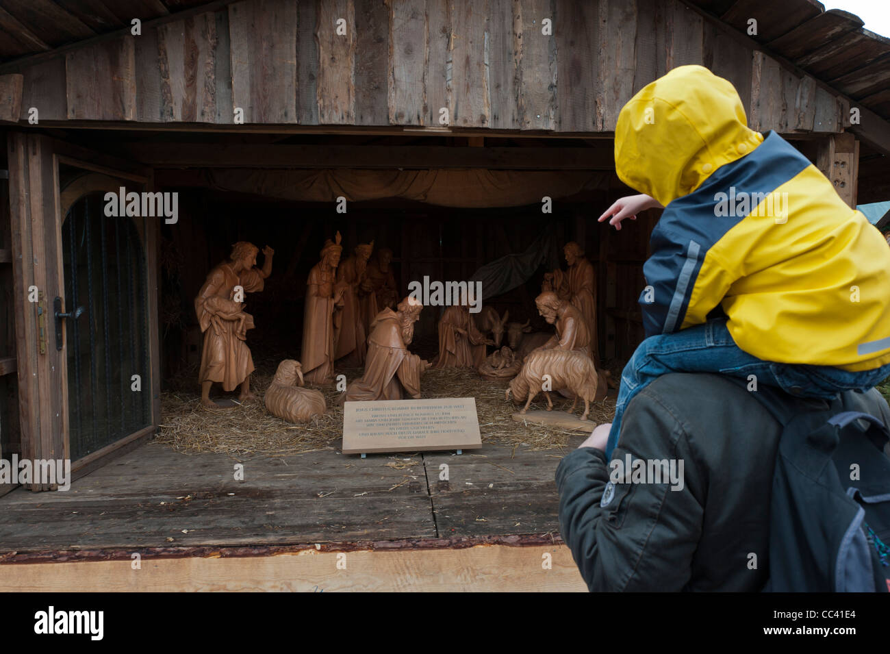 Nativity scene. Father and son admire the hand-carved wooden figures.Erfurt Christmas Market. Cathedral Square.Thuringia Germany Stock Photo